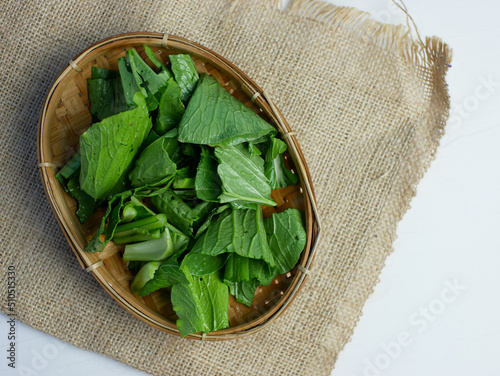 mustard greens in a bamboo container photo