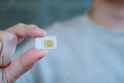 Man hand holding white sim card. Technology concept. photo