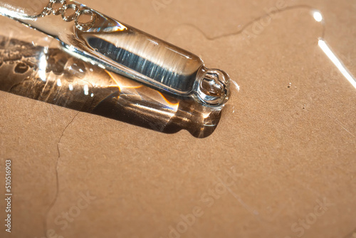 A pipette of cosmetic gel on a beige background. photo