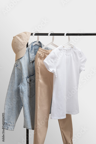 Blank white female t-shirt mockup. Basic women`s clothes. Woman collection of clothes on a rack. Spring and summer fashion trending concept. Railing with stylish female clothes © svetlana_nsk