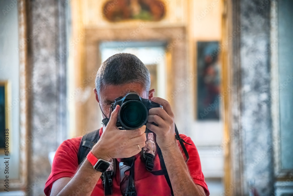 Male photographer taking pictures of a museum interior with a professional camera
