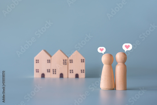 Small wooden faceless figures of human family members with heart icon and house. Property, hospitality, orphanage concept using wooden house and human model. photo