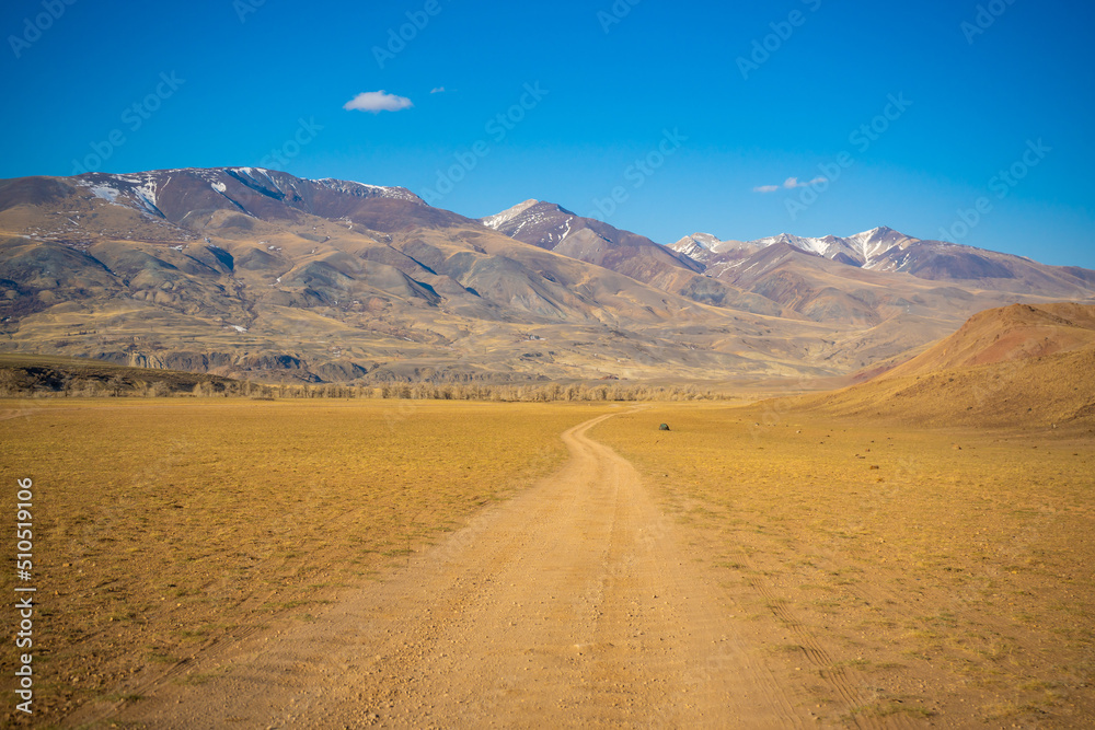 Road in Kyzyl-Chin valley or Mars valley with mountain background in Altai, Siberia, Russia. Road in Kyzyl-Chin valley or Mars valley with mountain background in Altai, Siberia, Russia.