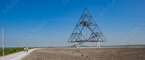 Panorama of a young couple walking to the tetrahedron in Bottrop, Germany photo