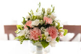 Fresh pink, white rose flower bouquet in transparent vase on table with print tablecloth. Marriage, wedding invitation
