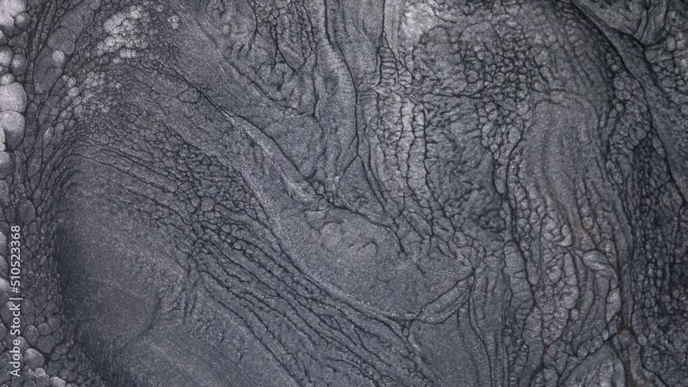 Abstract fluid background design of moving monochrome liquid silver shimmering ink. Lava flow, melting and seething of metals Abstract fluid background design of moving monochrome liquid silver shimmering ink. Lava flow, melting and seething of metals