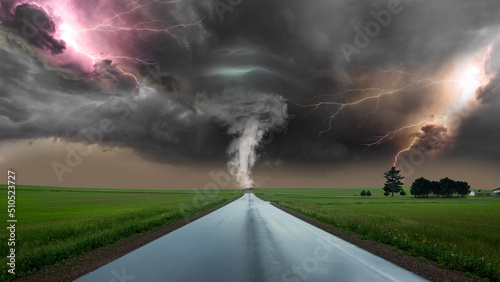 Tornado on a straight road. dramatic storm powerful tornado twisting through the countryside with sheet lightning. Along the road lightning. powerful lightning bolt strikes the ground in an open field