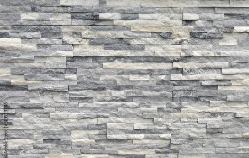 Stone cladding wall made of regular  bricks of white  gray and black rocks. Panels for exterior  background and texture. 