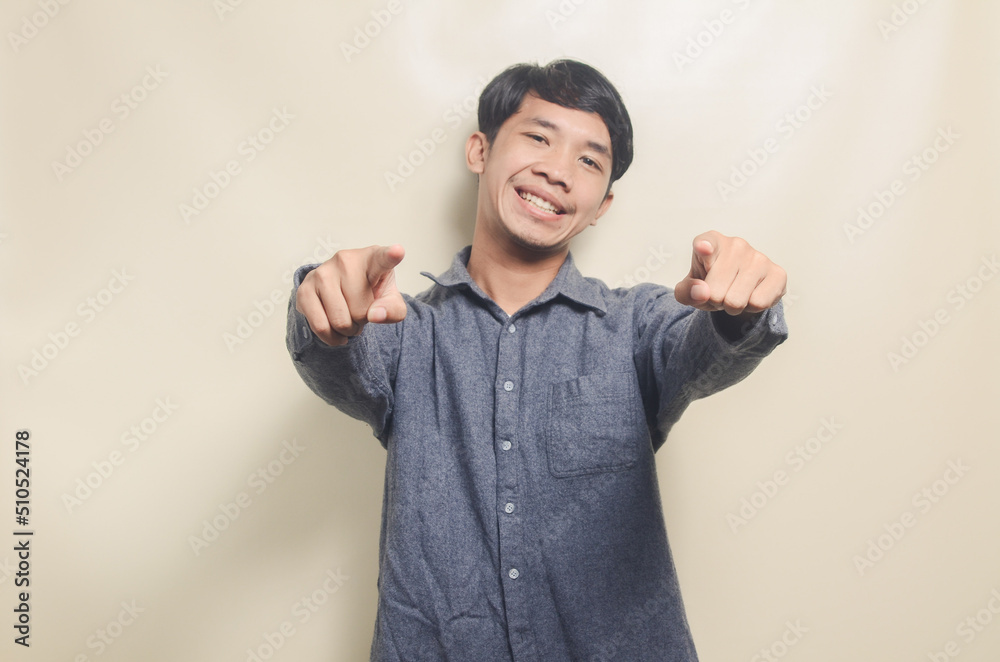 Portrait of handsome man in gray shirt with cheerful face showing victory Portrait of handsome man in gray shirt with cheerful face showing victory