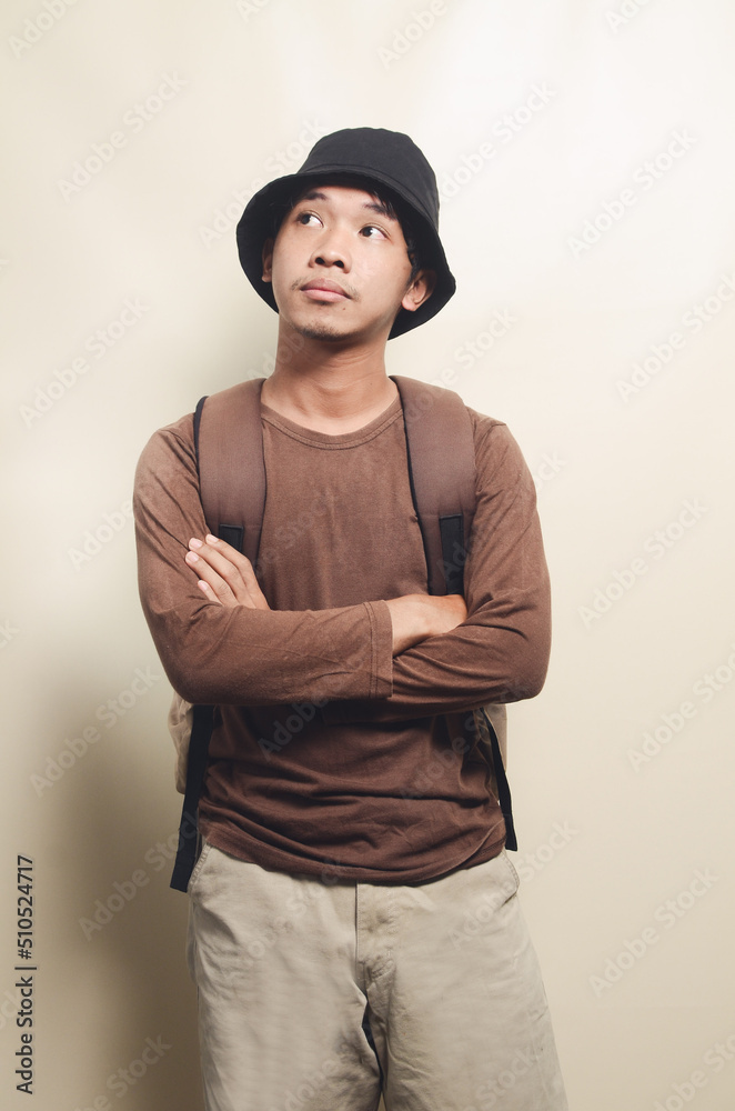 Portrait of thinking young asian boy carrying backpack isolated on background Portrait of thinking young asian boy carrying backpack isolated on background