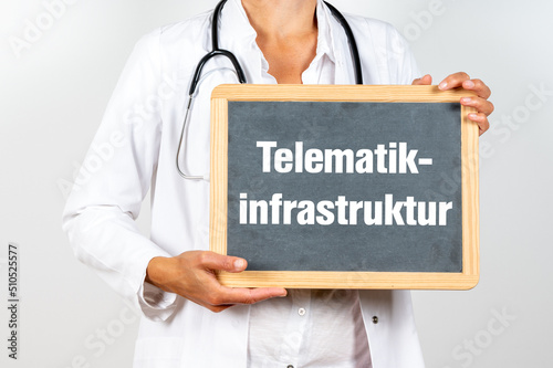 Ärztin mit einer Tafel auf der Telematikinfrastruktur steht