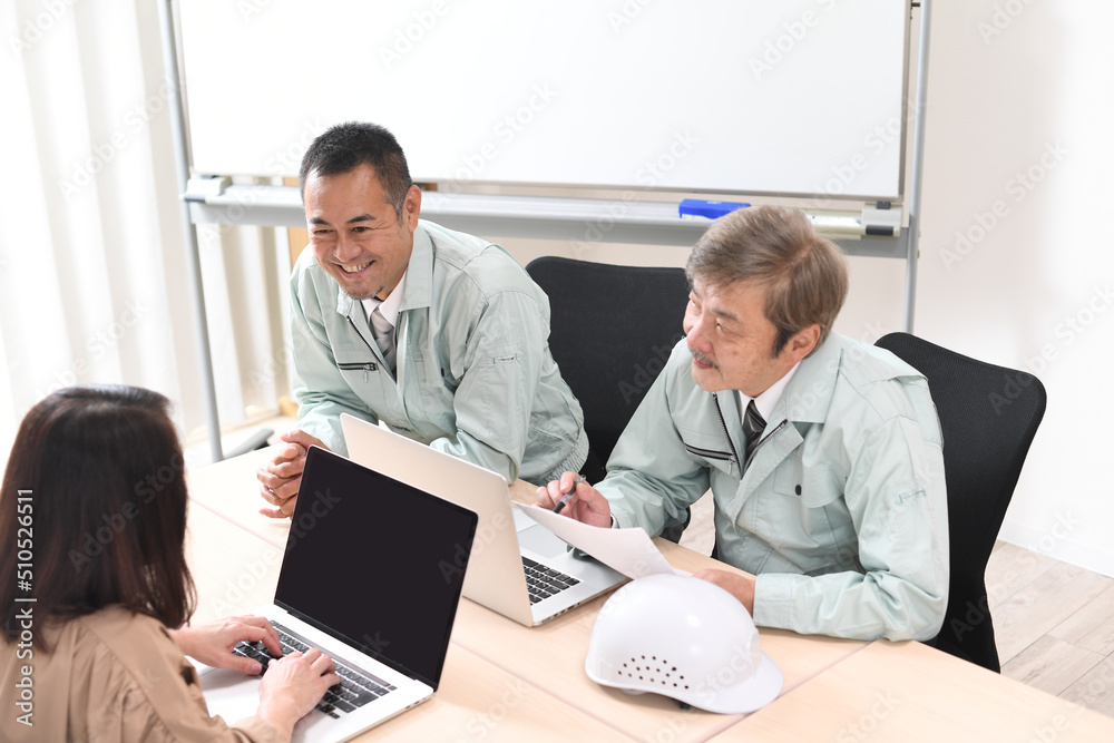 会話をする作業服を着た笑顔のミドル男性達
会話をする作業服を着た笑顔のミドル男性達