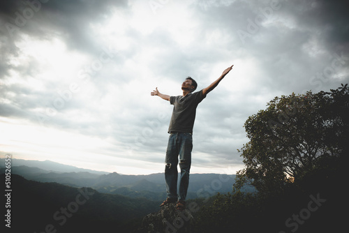 Man praying on the mountains raised hands Travel Lifestyle spiritual relaxation emotional concept, Freedom and travel adventure.