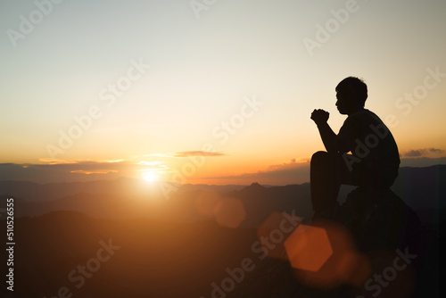 Man praying at sunset mountains raised hands Travel Lifestyle spiritual relaxation emotional concept  Freedom and travel adventure.