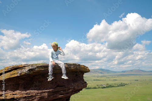 The boy sits on the top of the mountain, summer adventures, outdoor activities © Марина Мартьянова