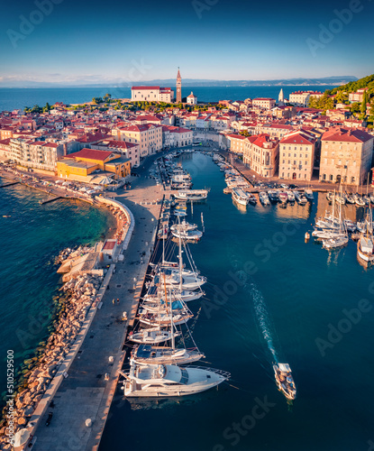 Last light glowing Slovenia Adriatic coast with beautiful Venetian architecture. Stunning morning cityscape of Piran town. View from flying drone of old port. Traveling concept background..
