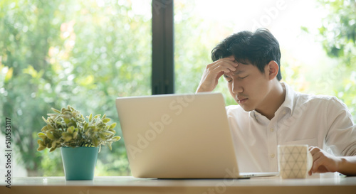 Obraz na plátne Young Asian man having stressful time working on laptop