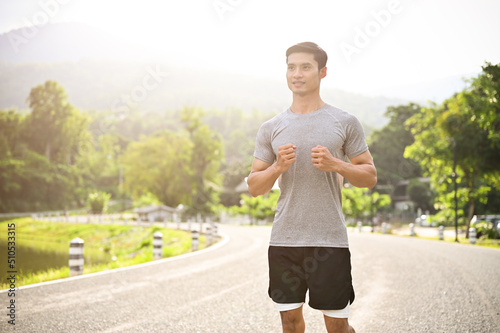 Handsome young Asian male runner in active sportswear running on the running sidewalk © bongkarn