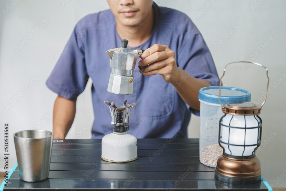 Asian boy learning to make coffee with moka pot. Asian boy learning to make coffee with moka pot.