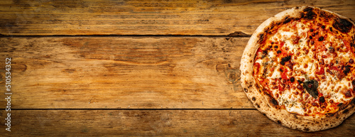 Pizza food background. Homemade Neapolitan pizza Margherita with mozzarella cheese and tomato sauce on a rustic wooden table. Italian food.