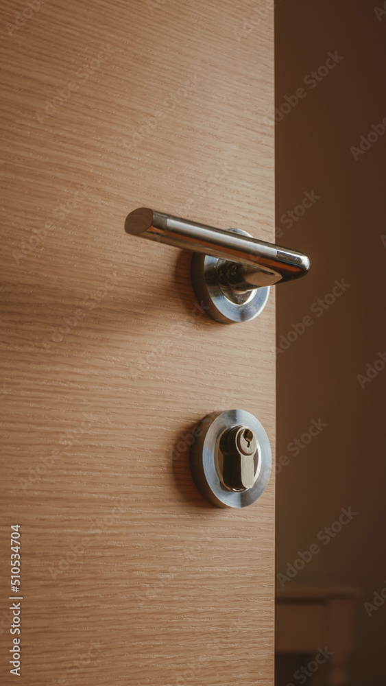 Modern metallic door handle on medium density fiberboard bedroom door Modern metallic door handle on medium density fiberboard bedroom door