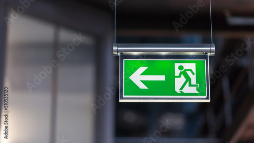 Foto Illuminated emergency exit sign. Arrow pointing to the left.