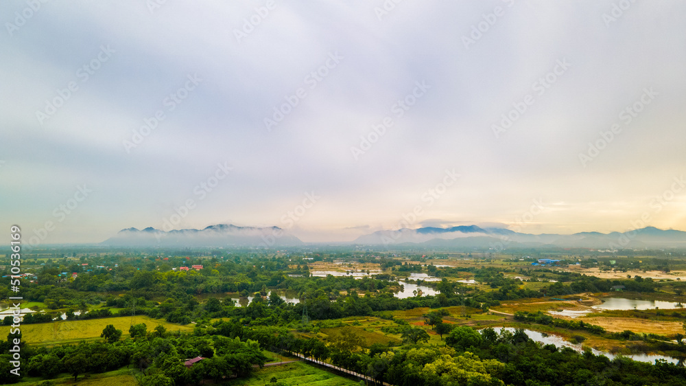 Photograph of beautiful countryside green tree forrest landscape. Mountain hill as blue background. Aerial photograph. View of the countryside at sunrise