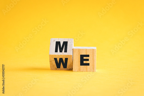 Wooden cube blocks flip from me to we. Teamwork concept. On yellow background. photo