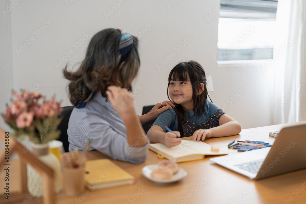 Older woman grandma and little girl grandkid with homework remote study. Attentive mature old female tutor give private lesson to small child pupil Older woman grandma and little girl grandkid with homework remote study. Attentive mature old female tutor give private lesson to small child pupil