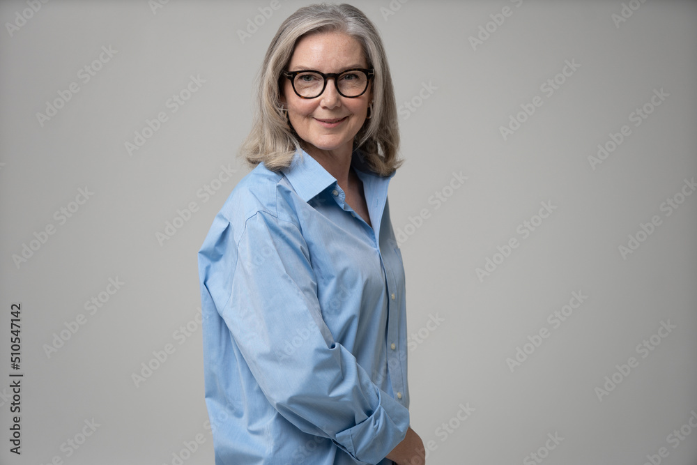 Elegant mid adult woman against white background. Stylish mature woman in blue casuals looking at camera and smiling Elegant mid adult woman against white background. Stylish mature woman in blue casuals looking at camera and smiling