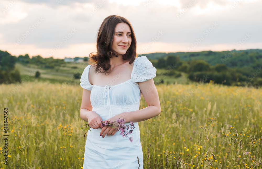 young happy female walking in the field enjoying beautiful sunset. Beautiful countryside. Slow living concept young happy female walking in the field enjoying beautiful sunset. Beautiful countryside. Slow living concept