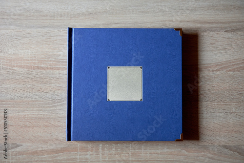 Wood blue wedding photobook on wooden table background, copy space. Mockup template. Top view, flat lay