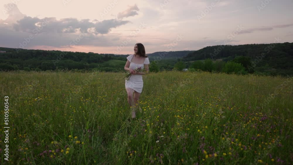 4k slow motion shot of young happy female walking in the field enjoying beautiful sunset. Beautiful countryside. Slow living concept 4k slow motion shot of young happy female walking in the field enjoying beautiful sunset. Beautiful countryside. Slow living concept