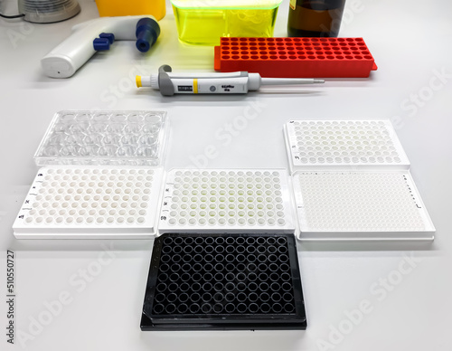 Different types of multiwell plates on the laboratory bench. Such plates are used for biological in vitro drug screening, biochemical assays, cytotoxicity evaluation, and enzyme activity assessment. photo