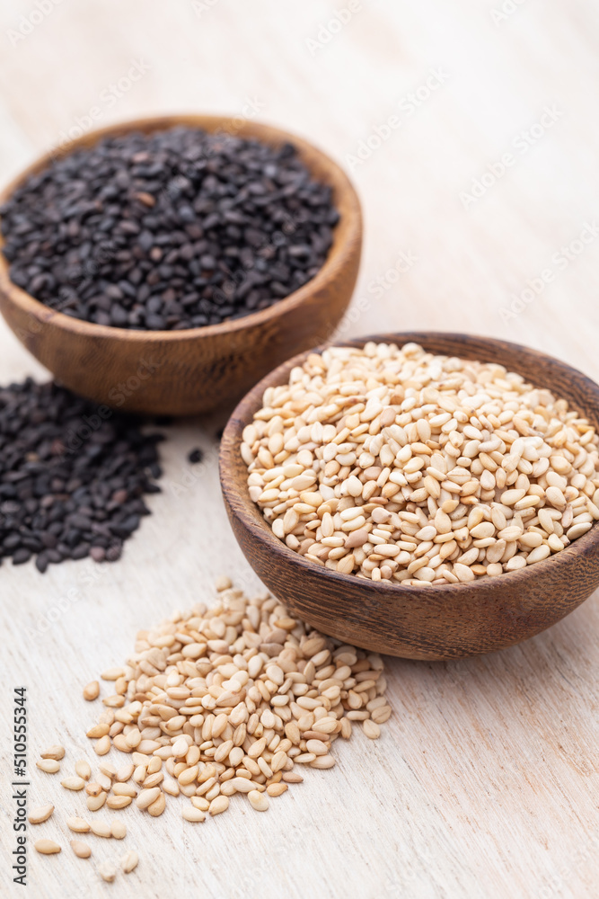 White sesame and black sesame seed on wooden bowl. White sesame and black sesame seed on wooden bowl.