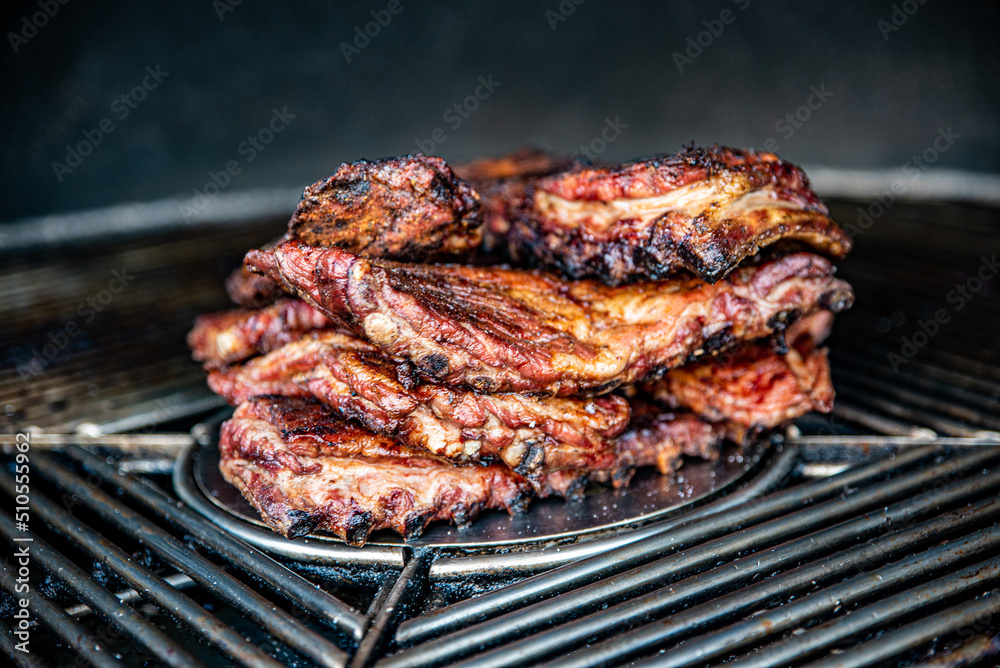 Stack of grilled pork ribs in grill