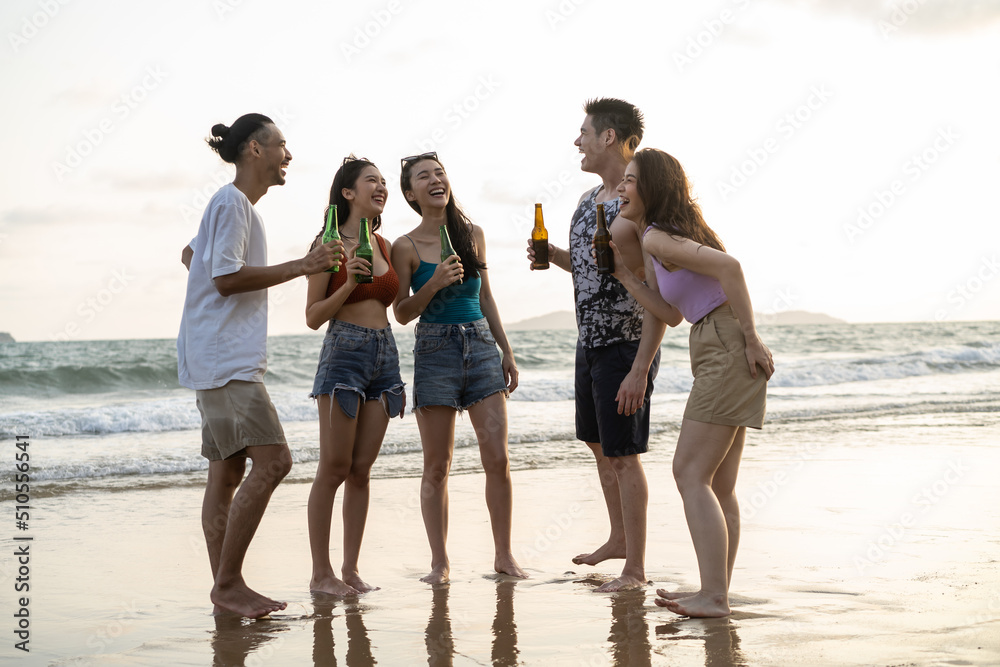 Group of Asian young man and woman having party on the beach together. Group of Asian young man and woman having party on the beach together.