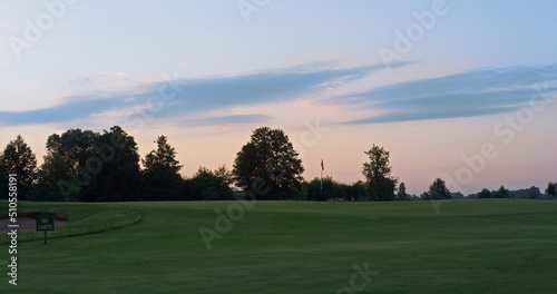 Beautiful sunset golf course park. Sun setting on dawn park landscape in evening