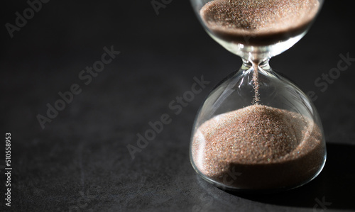 hourglass (sand clock) on a black background, Hourglass as time passing concept for business deadline, Life-time passing concept, elapsed time concept, with copy space