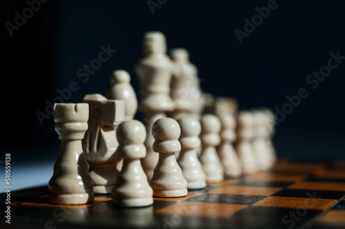 Chessboard with pieces on a white table. 