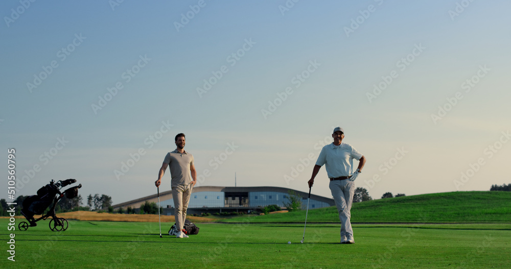 Two men enjoy golf on fairway field club. Golfing team practicing play sport.
