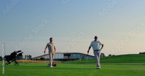 Two men enjoy golf on fairway field club. Golfing team practicing play sport.