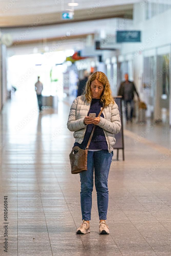 Aalborg, Denmark A woman looks at her phone in the terminal of the airport.