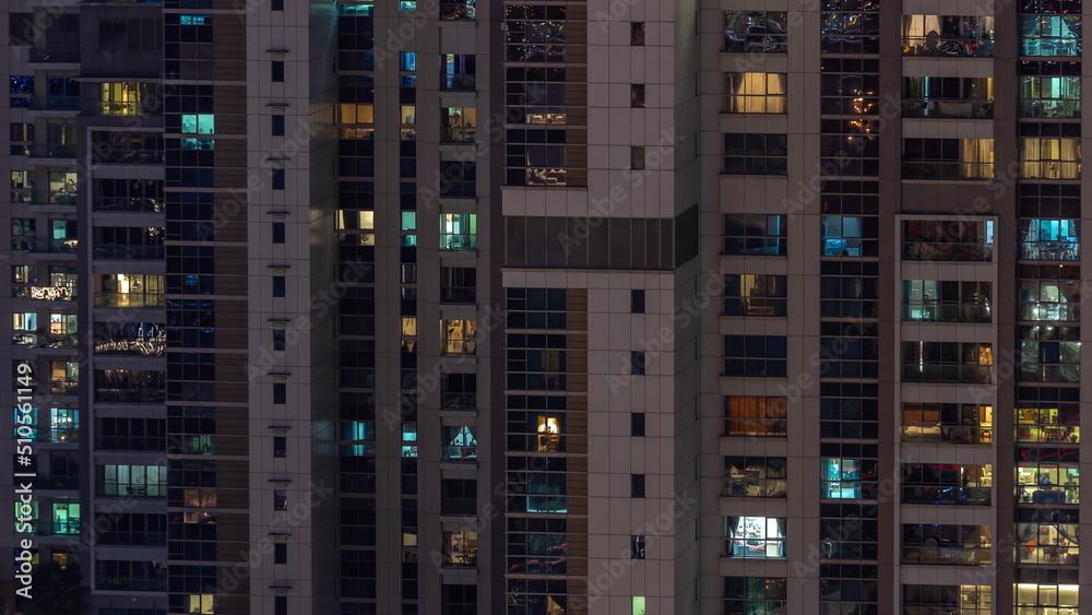 Apartment windows of a glazed skyscraper glow at night with city lights reflection aerial timelapse. Apartment windows of a glazed skyscraper glow at night with city lights reflection aerial timelapse.