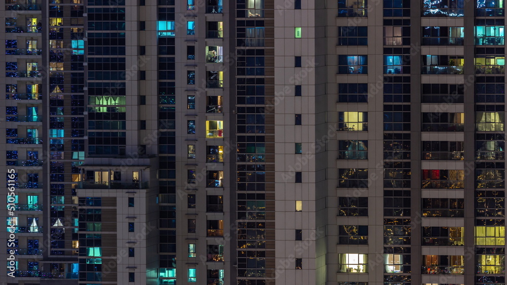 Apartment windows of a glazed skyscraper glow at night with city lights reflection aerial timelapse. Apartment windows of a glazed skyscraper glow at night with city lights reflection aerial timelapse.