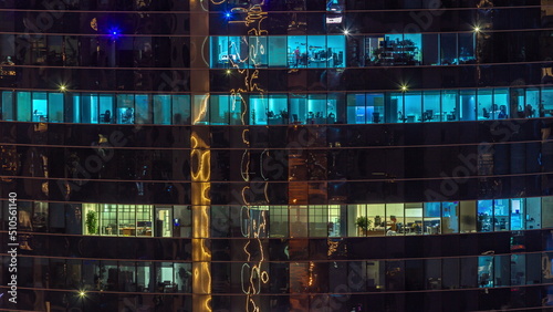 Photography Office windows of a glazed skyscraper glow at night with city lights reflection aerial timelapse