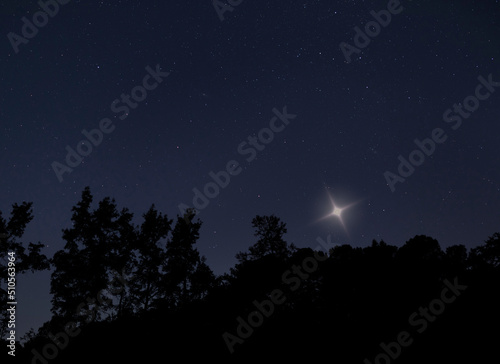 Shining star over a North Carolina treeline © Guy Sagi