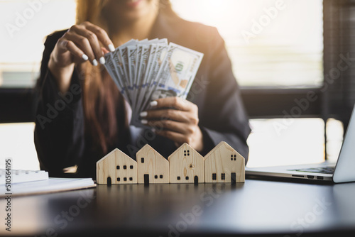 Real estate agent businesswoman counting cash, deposit or commission on real estate sales.