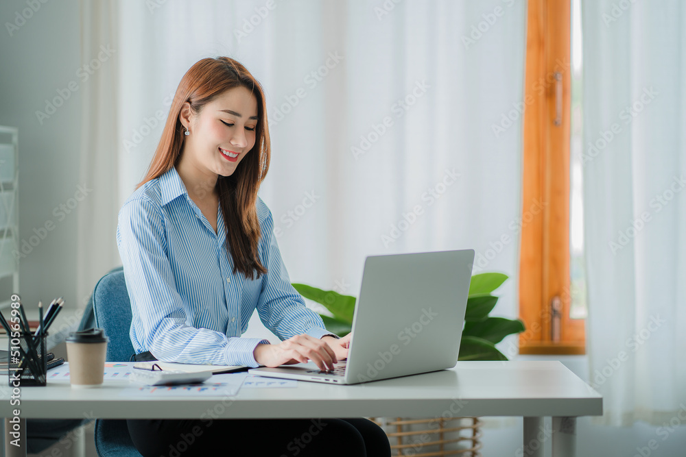 Asian businesswoman working in the office with laptop financial documents gives a clear vision of work and success instilling trust in business finance ideas. Asian businesswoman working in the office with laptop financial documents gives a clear vision of work and success instilling trust in business finance ideas.