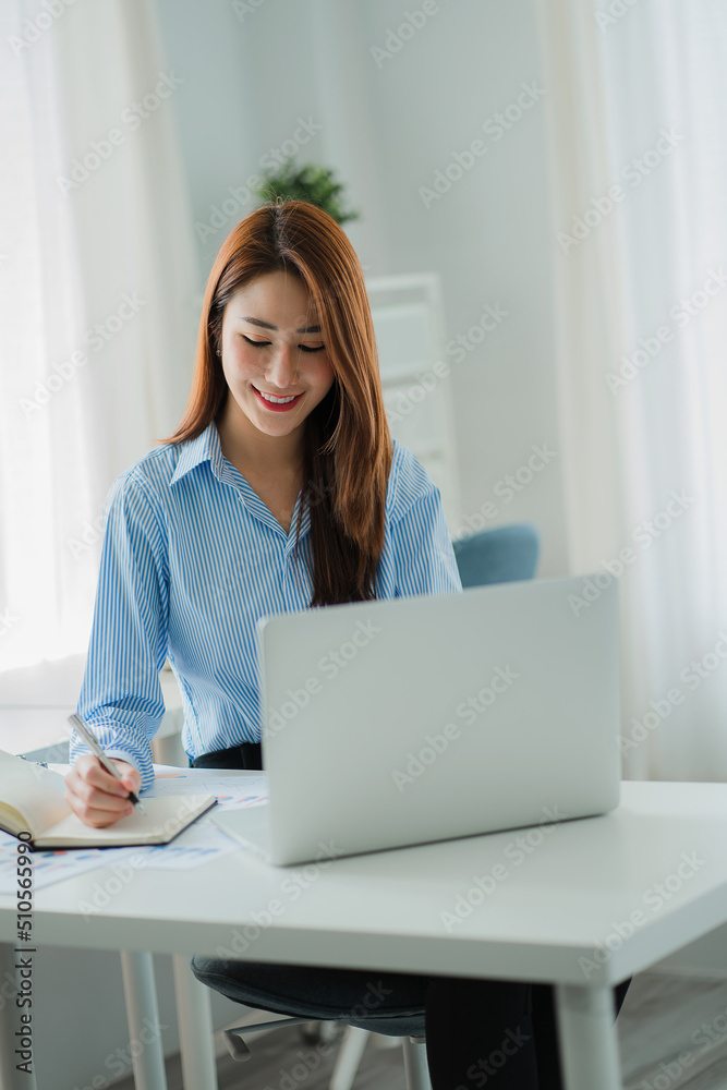 Asian businesswoman working on laptop computer in office with documents on desk woman looking at financial statistics data analysis chart profit growth business idea vertical image Asian businesswoman working on laptop computer in office with documents on desk woman looking at financial statistics data analysis chart profit growth business idea vertical image